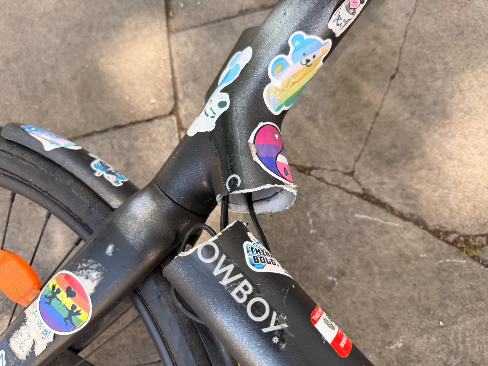 Close-up of a Cowboy C4 ST frame snapped clean through at the headtube joint, the COWBOY wordmark visible just below the break.